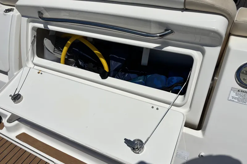 Slide: The Image of Open storage compartment on a 2013 Sea Ray Sundancer 310 boat, showing interior contents. - 5