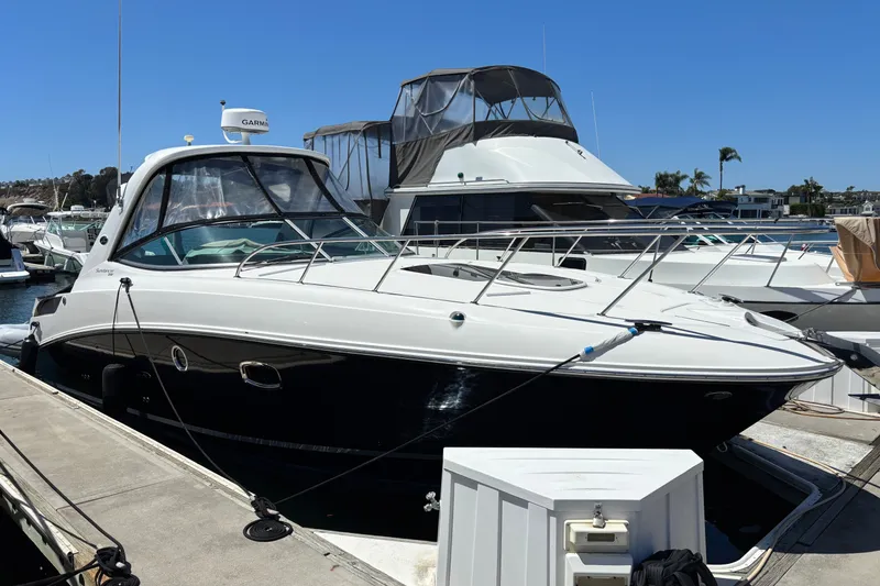 Slide: The Image of 2013 Sea Ray Sundancer 310 docked at marina under clear blue sky. - 3