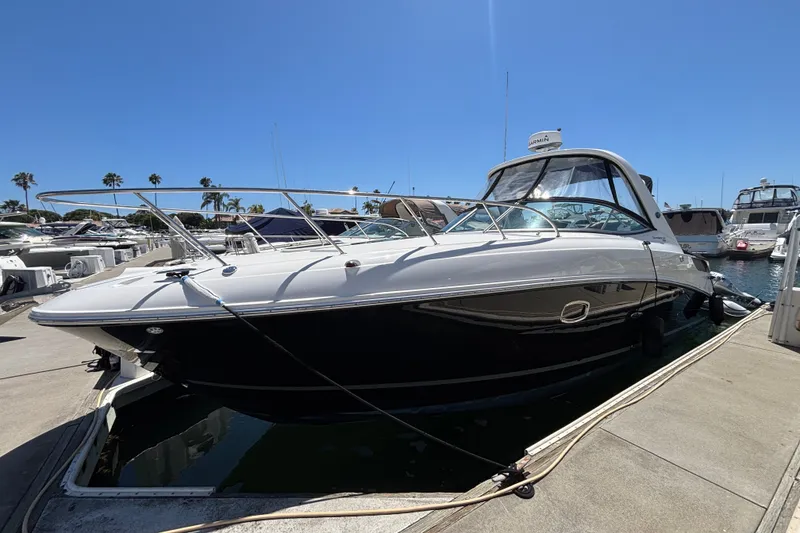 The Image of 2013 Sea Ray Sundancer 310 docked at marina under clear blue sky. - 2