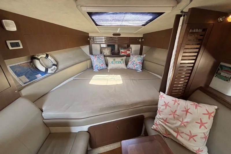 Slide: The Image of Interior of 2013 Sea Ray Sundancer 310, featuring cozy cabin with decorative pillows. - 27