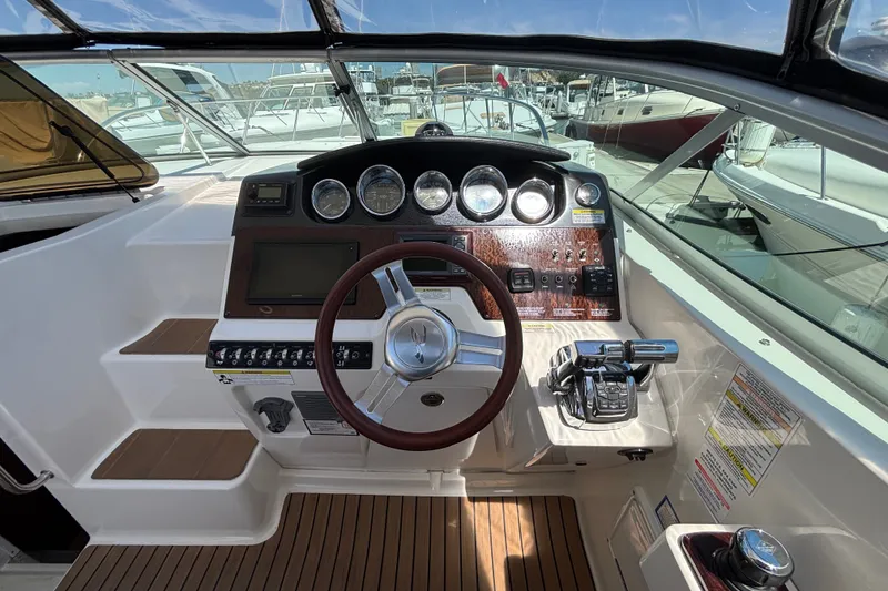 Slide: The Image of Cockpit of 2013 Sea Ray Sundancer 310 with steering wheel and control panel. - 15