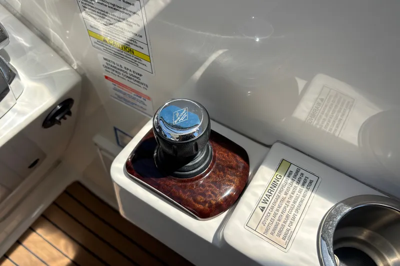 Slide: The Image of Joystick control on 2013 Sea Ray Sundancer 310 boat, with warning labels and wood trim. - 19