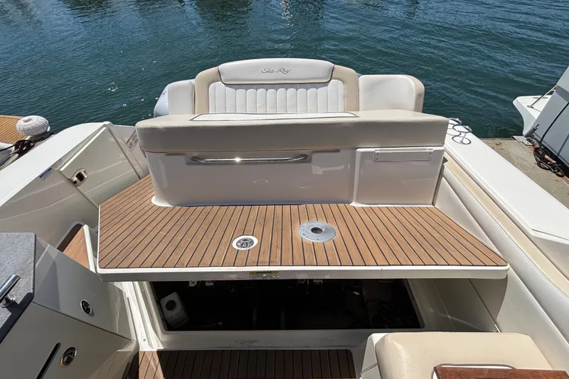 Slide: The Image of 2013 Sea Ray Sundancer 310 boat with teak deck and cushioned seating by the water. - 32