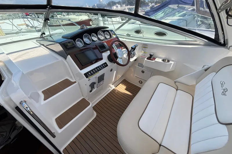 Slide: The Image of Interior cockpit of 2013 Sea Ray Sundancer 310, featuring helm controls and seating. - 14