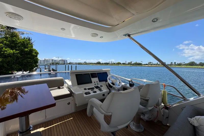 Slide: The Image of Flybridge view of 2018 Azimut 66 yacht, overlooking serene waterfront and clear blue sky. - 20