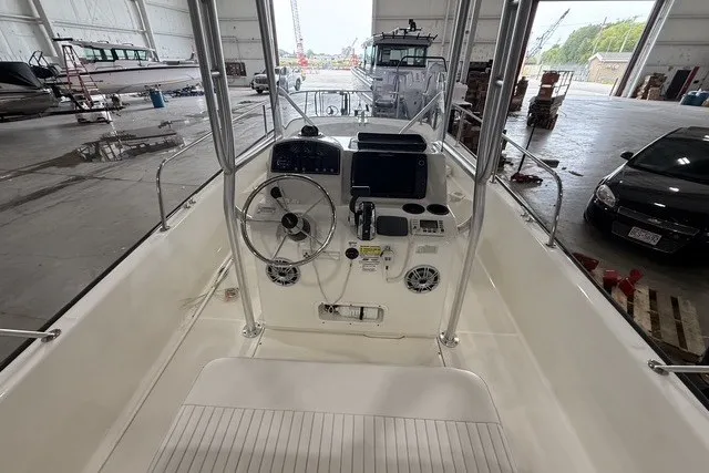 Slide: The Image of 2015 Boston Whaler 210 Montauk boat interior with steering console in a warehouse setting. - 7
