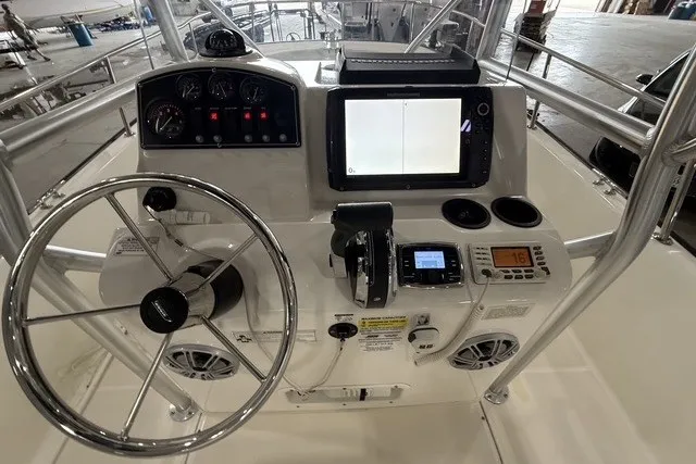 Slide: The Image of Control panel of a 2015 Boston Whaler 210 Montauk boat with steering wheel and navigation equipment. - 8