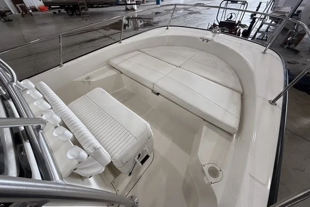 Slide: The Image of 2015 Boston Whaler 210 Montauk boat interior with white cushioned seating and stainless steel railings. - 11