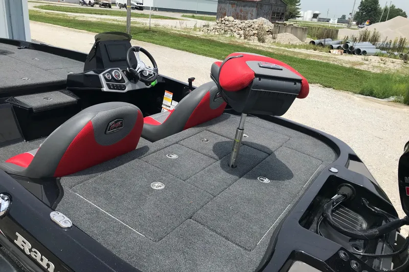 Slide: The Image of 2024 Ranger Z185 boat interior with red and gray seating, steering console, and carpeted deck. - 5
