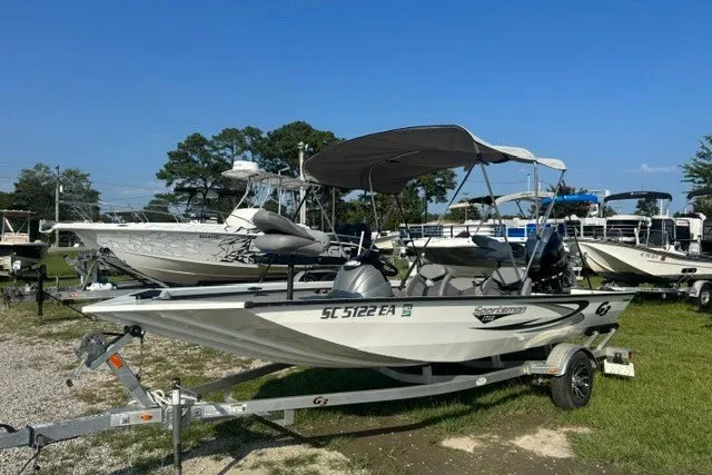 The Image of 2022 G3 Sportsman 1710 PFX boat on trailer, parked outdoors under clear blue sky. - 1