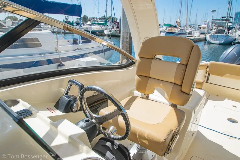 Slide: The Image of Helm of 2017 Scout 275 Dorado boat with tan seating, docked at marina. - 31