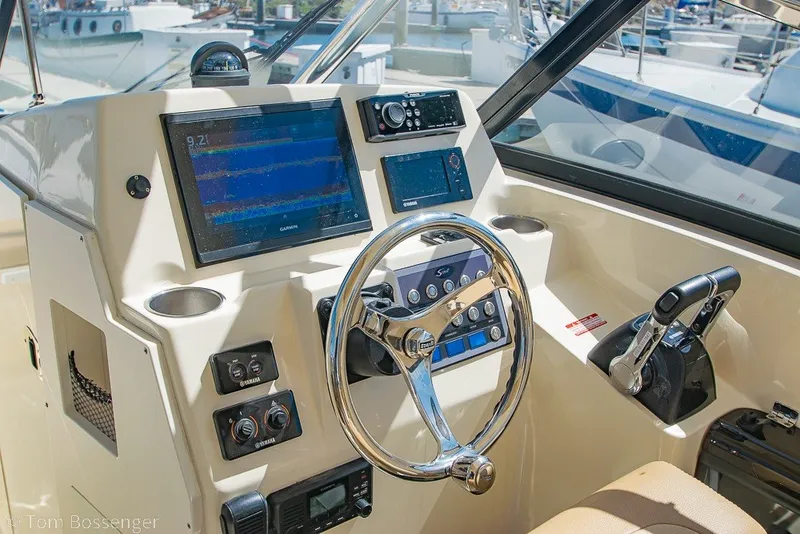 Slide: The Image of 2017 Scout 275 Dorado boat dashboard with steering wheel and navigation controls. - 30