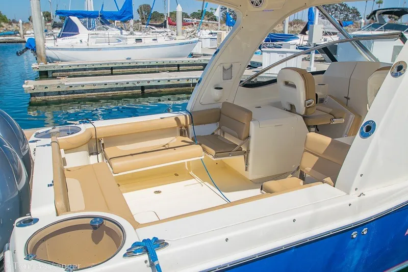 Slide: The Image of 2017 Scout 275 Dorado boat interior at marina, featuring seating and fishing amenities. - 18