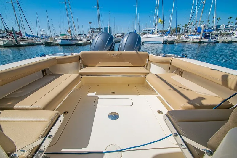 Slide: The Image of 2017 Scout 275 Dorado boat interior with tan seating, docked in a marina. - 14