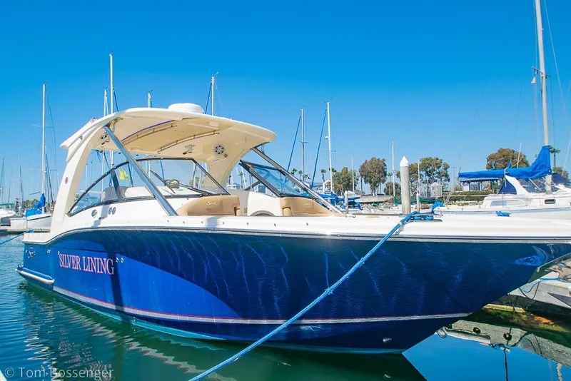 Slide: The Image of 2017 Scout 275 Dorado boat named "Silver Lining" docked in a marina under clear blue skies. - 1