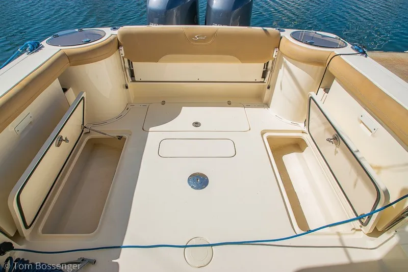 Slide: The Image of 2017 Scout 275 Dorado boat deck with storage compartments open, docked on water. - 10