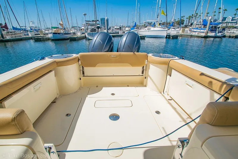 Slide: The Image of 2017 Scout 275 Dorado boat interior at marina with twin engines and seating. - 9