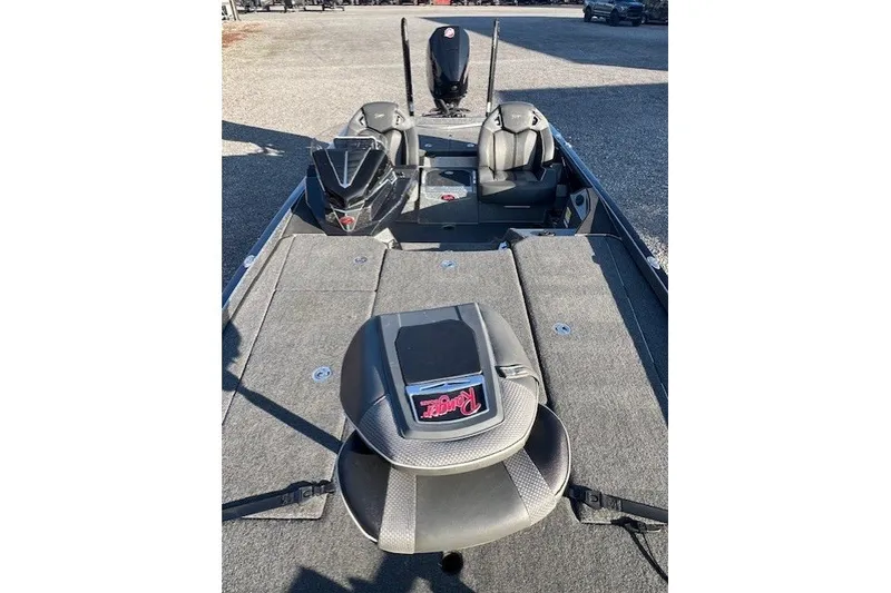 The Image of 2024 Ranger Z521R fishing boat interior with seating and motor, parked on gravel. - 1