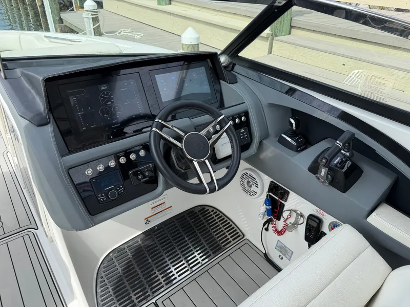 Slide: The Image of The image shows the cockpit of a 2021 Cobalt 30SC boat with modern instruments and controls. - 24