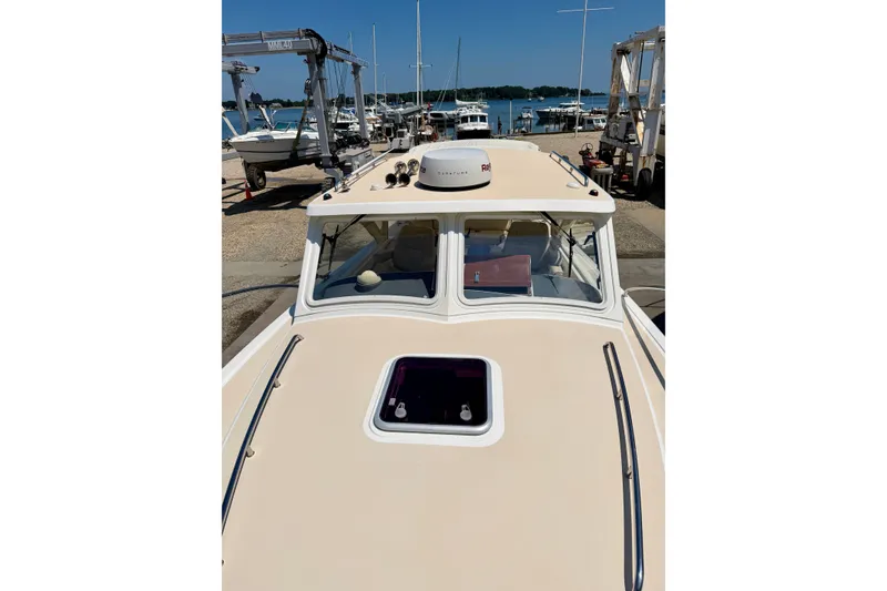 Slide: The Image of 2009 MJM 29z Downeast boat docked, showcasing its sleek design and spacious deck. - 26