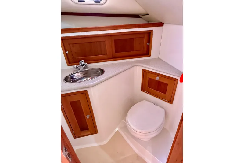 Slide: The Image of 2009 MJM 29z Downeast boat bathroom with sink, toilet, and wooden cabinets. - 17