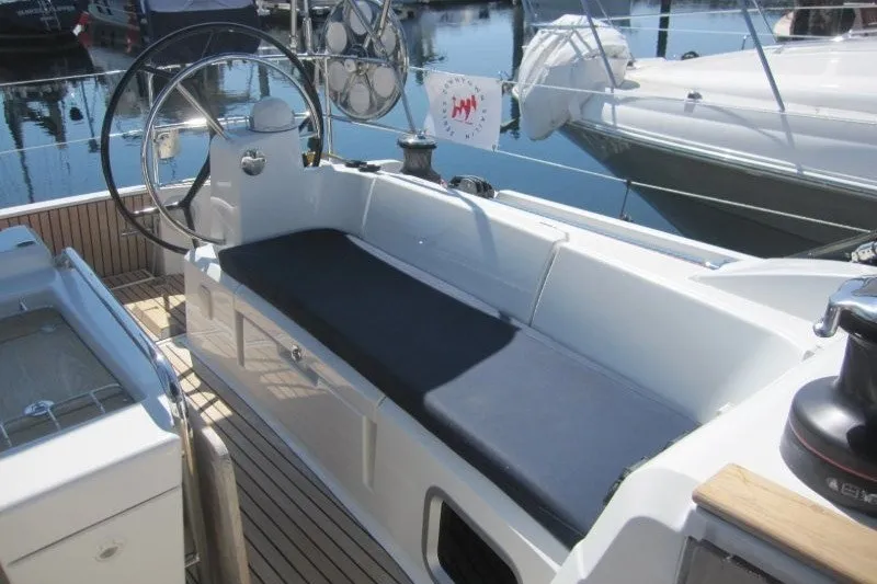 Slide: The Image of 2013 Jeanneau Sun Odyssey 469 cockpit with steering wheel and seating, docked at marina. - 39