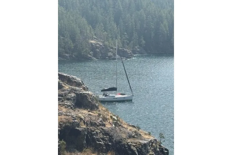 Slide: The Image of Sailboat Jeanneau Sun Odyssey 469, 2013, anchored in a scenic, forested bay. - 51