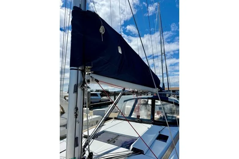 Slide: The Image of 2013 Jeanneau Sun Odyssey 469 sailboat with covered mainsail, docked under a blue sky. - 32