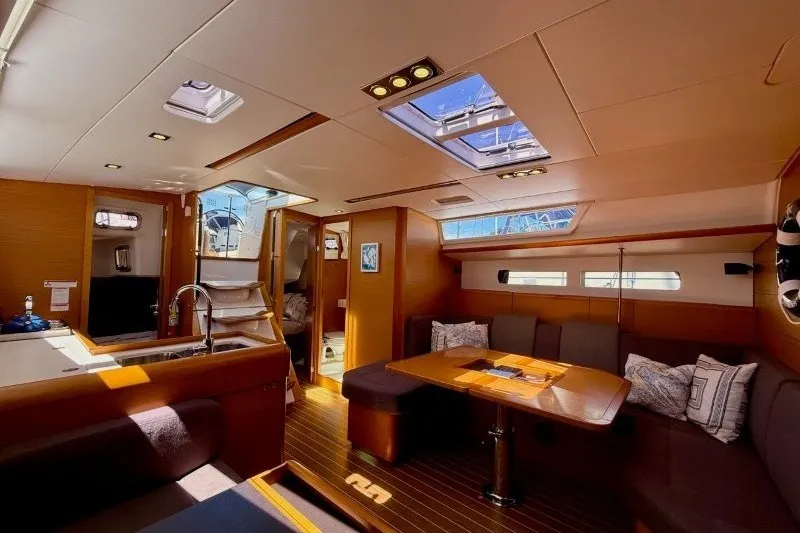 Slide: The Image of Interior of 2013 Jeanneau Sun Odyssey 469 yacht, featuring elegant wood finishes and spacious seating. - 16