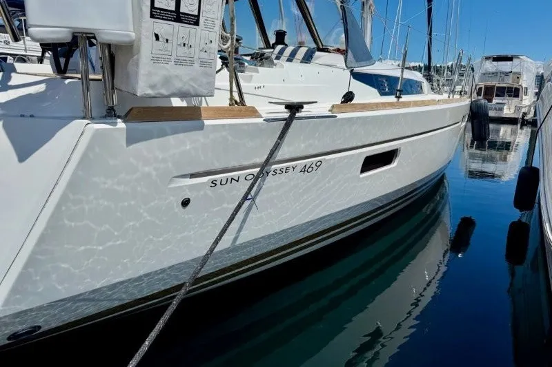 Slide: The Image of 2013 Jeanneau Sun Odyssey 469 sailboat docked in a marina, reflecting on calm water. - 26