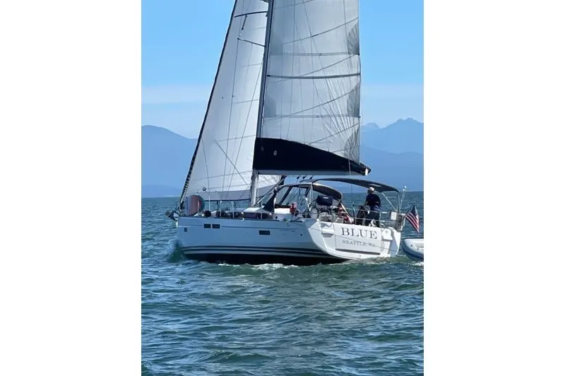 The Image of 2013 Jeanneau Sun Odyssey 469 sailing on open water with mountains in the background. - 0