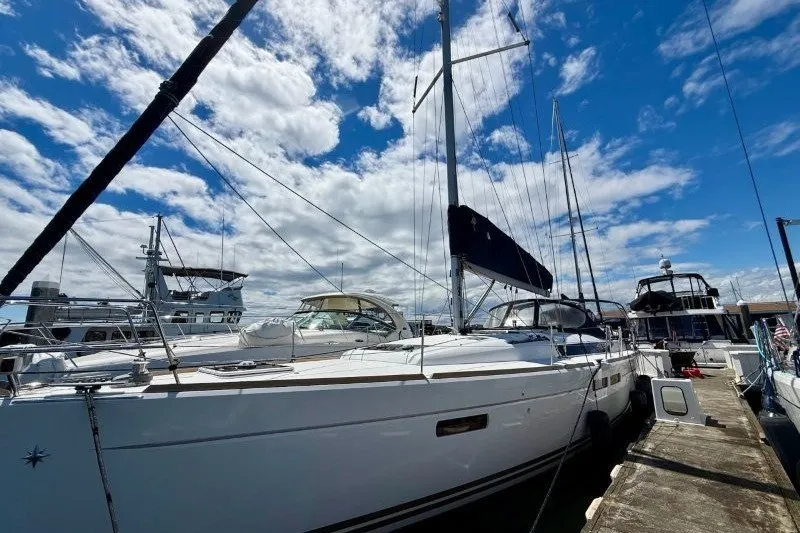 Slide: The Image of 2013 Jeanneau Sun Odyssey 469 sailboat docked under a bright blue sky. - 33