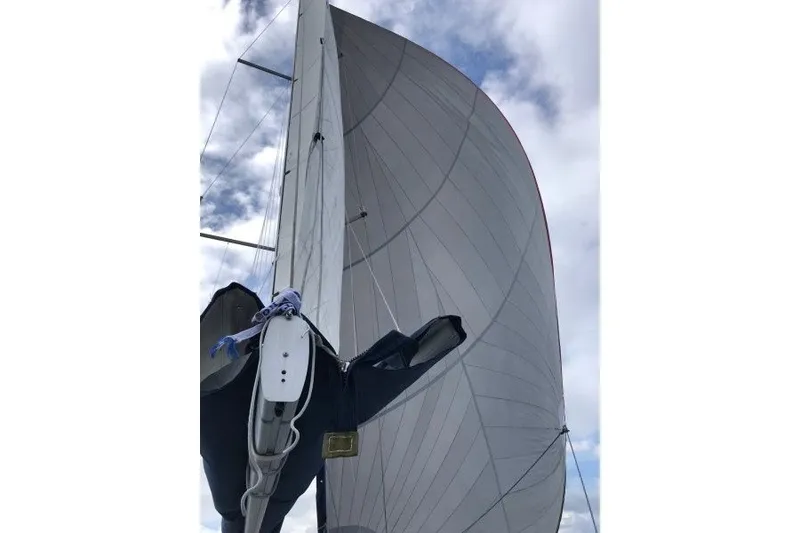 Slide: The Image of Sailing yacht Jeanneau Sun Odyssey 469, 2013 model, with sails unfurled against a cloudy sky. - 50