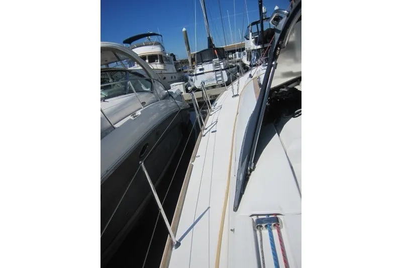 Slide: The Image of 2013 Jeanneau Sun Odyssey 469 sailboat docked among other boats in a marina. - 41