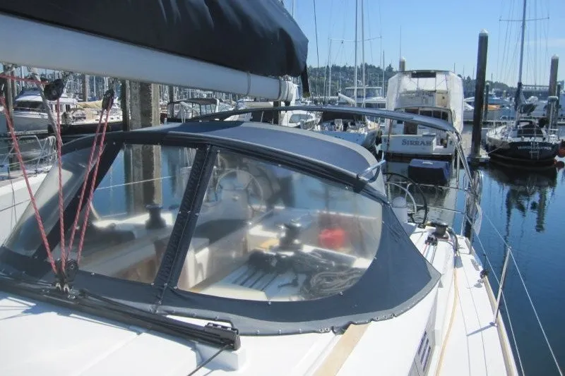 Slide: The Image of 2013 Jeanneau Sun Odyssey 469 sailboat docked in a marina, featuring a sleek cockpit design. - 43