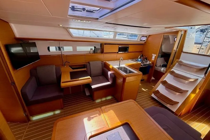 Slide: The Image of Interior of 2013 Jeanneau Sun Odyssey 469 yacht, featuring modern seating and kitchen area. - 13