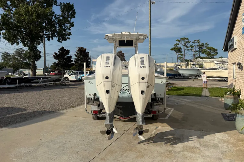 Slide: The Image of 2002 Silverhawk 240 Center Console boat with twin outboard engines in a marina setting. - 6