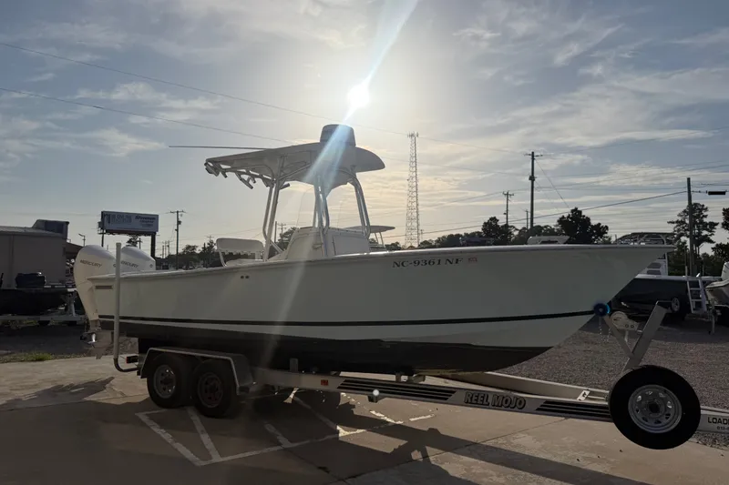Slide: The Image of 2002 Silverhawk 240 Center Console boat on trailer, sunlit background, parked outdoors. - 10