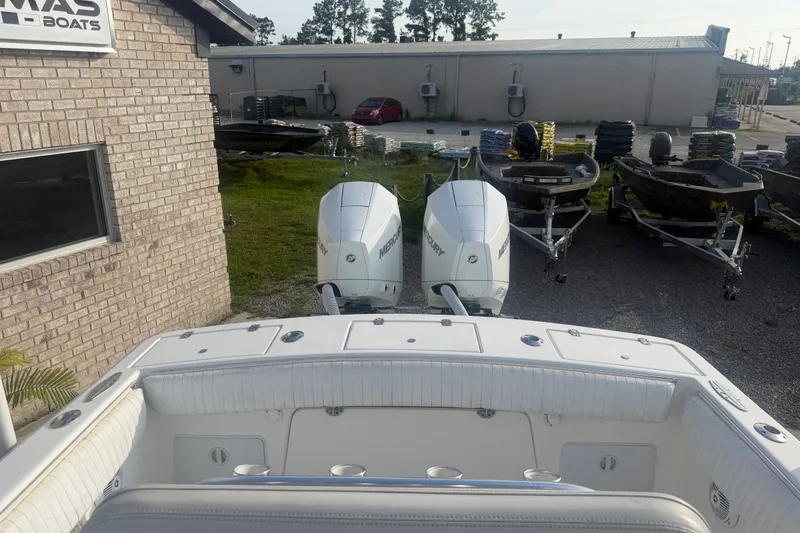 Slide: The Image of 2002 Silverhawk 240 Center Console boat with dual Mercury engines, parked near a brick building. - 15