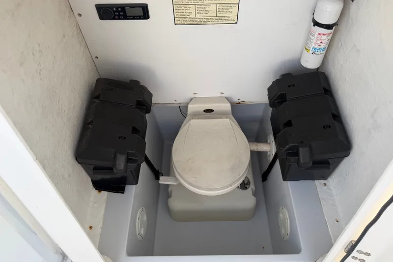 Slide: The Image of Boat toilet compartment in 2002 Silverhawk 240 Center Console, featuring essential equipment. - 28