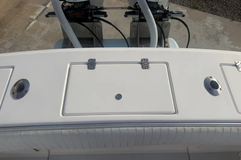 Slide: The Image of 2002 Silverhawk 240 Center Console boat deck with storage hatch and rod holders. - 19