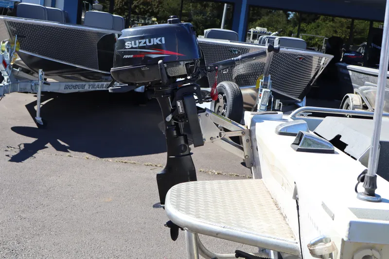 Slide: The Image of Boat with Suzuki outboard motor, Tacoma Jet 17' Mechanic's Special, 2007 model, parked outdoors. - 5