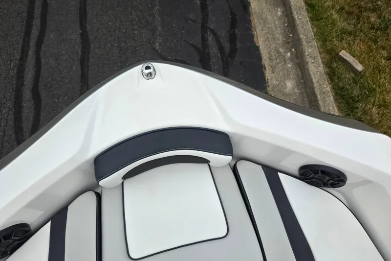 Slide: The Image of 2023 Yamaha Boats AR195 bow seating area with sleek white and black upholstery. - 19