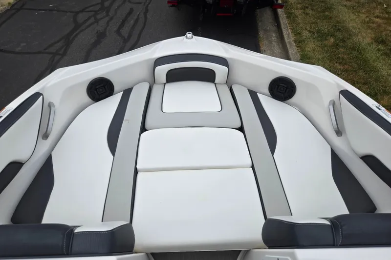 Slide: The Image of 2023 Yamaha Boats AR195 interior seating with sleek white and gray upholstery. - 18