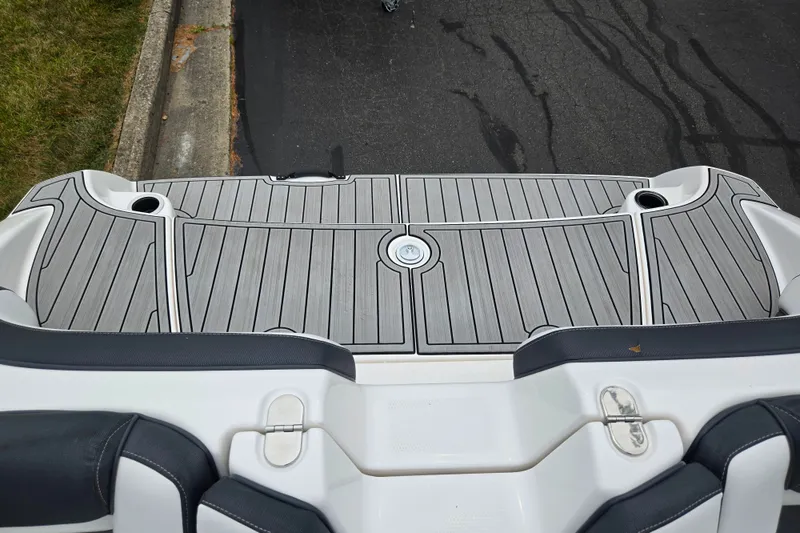 Slide: The Image of 2023 Yamaha Boats AR195 swim platform with sleek gray decking and cup holders. - 25
