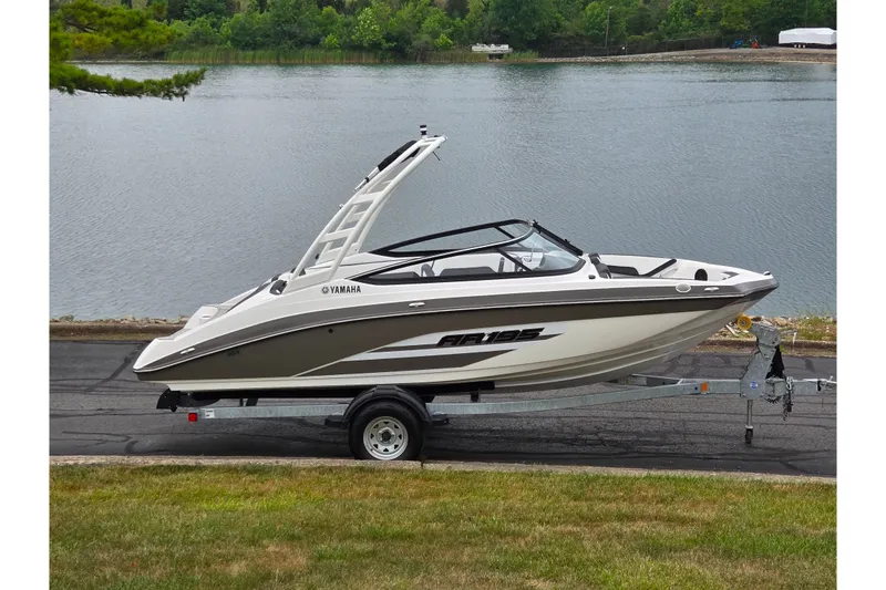 The Image of 2023 Yamaha AR195 boat on trailer by a lake, showcasing sleek design and modern features. - 0