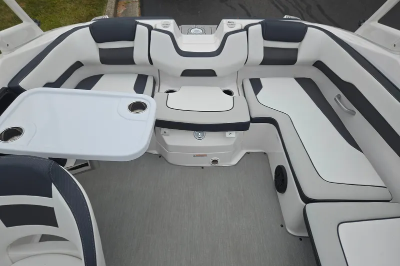 Slide: The Image of 2023 Yamaha Boats AR195 interior with sleek seating and a convenient table setup. - 23