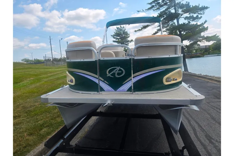 Slide: The Image of 2012 Avalon A Fish 16' pontoon boat on trailer by a lake. - 6