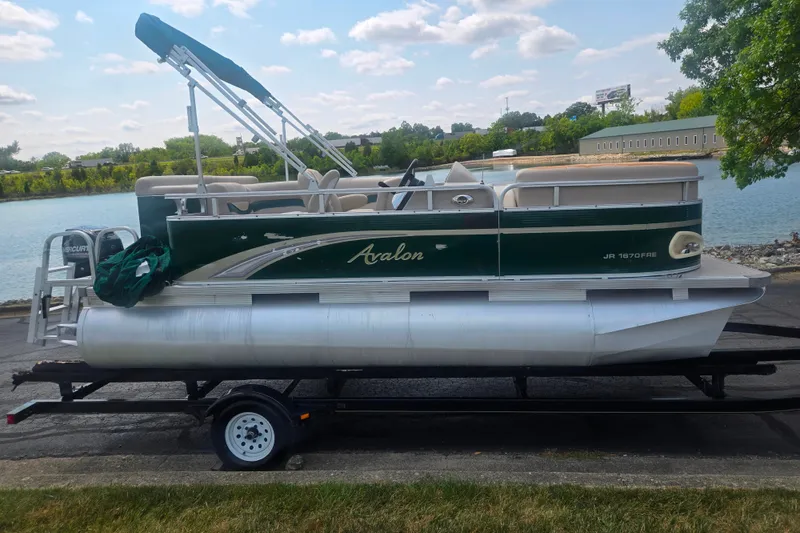 Slide: The Image of 2012 Avalon A Fish 16' pontoon boat on trailer by a lake. - 9