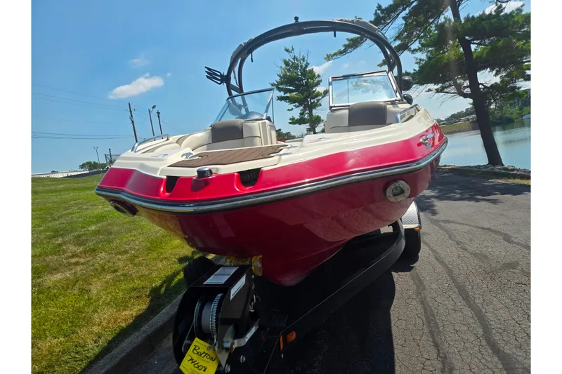 Slide: The Image of 2014 Yamaha Boats 242 Limited S in vibrant red, parked near a scenic lake. - 6